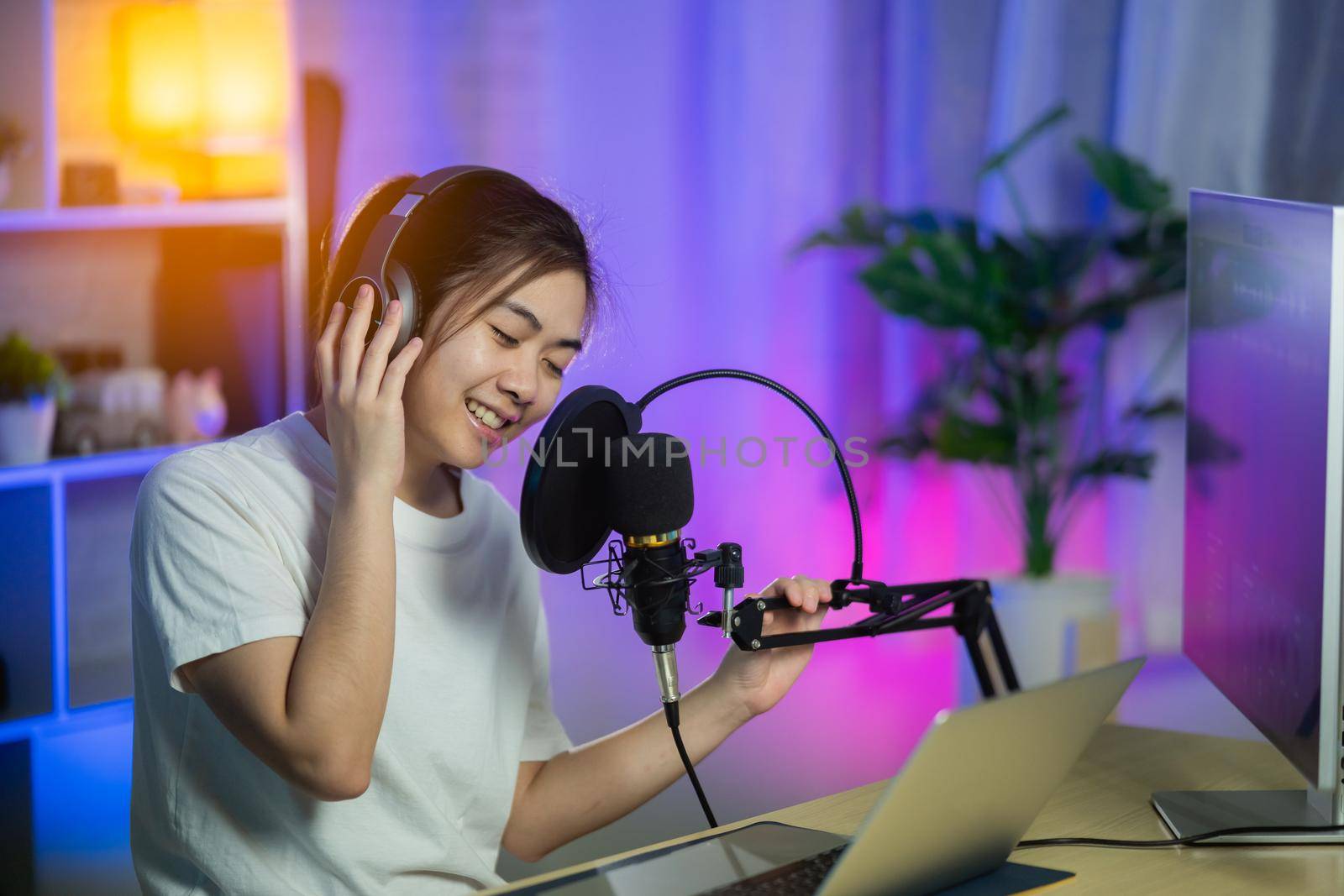 singer women singing with headphone recording new song in the home recording studio by Wmpix