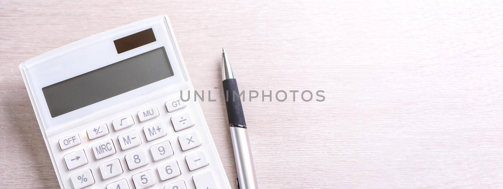 White calculator and pen on bright wooden table, analytics and statistics of financial profit, investment risk concept, copy space, top view flat lay by ROMIXIMAGE
