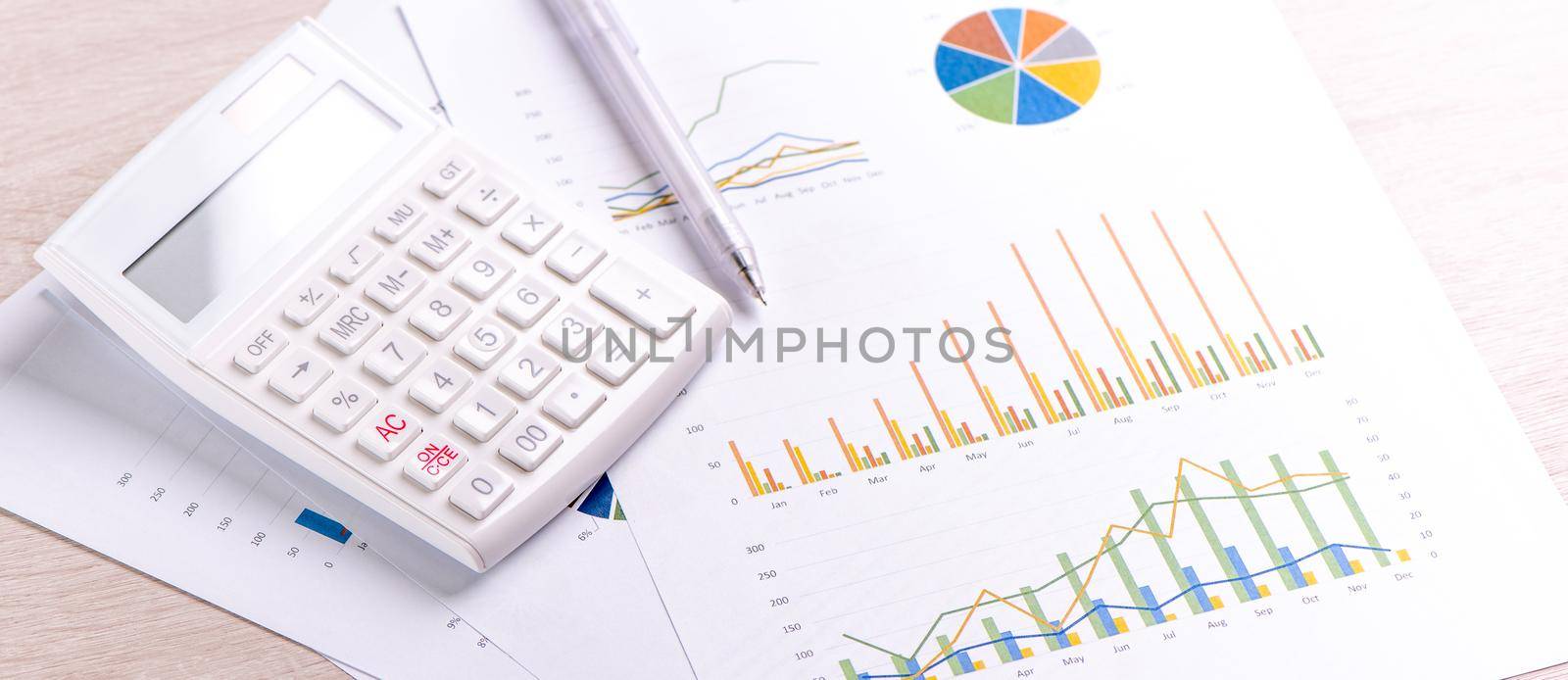 White calculator and report with chart and graph, concept of annual financial profit overview, banking and investment, close up, copy space, macro