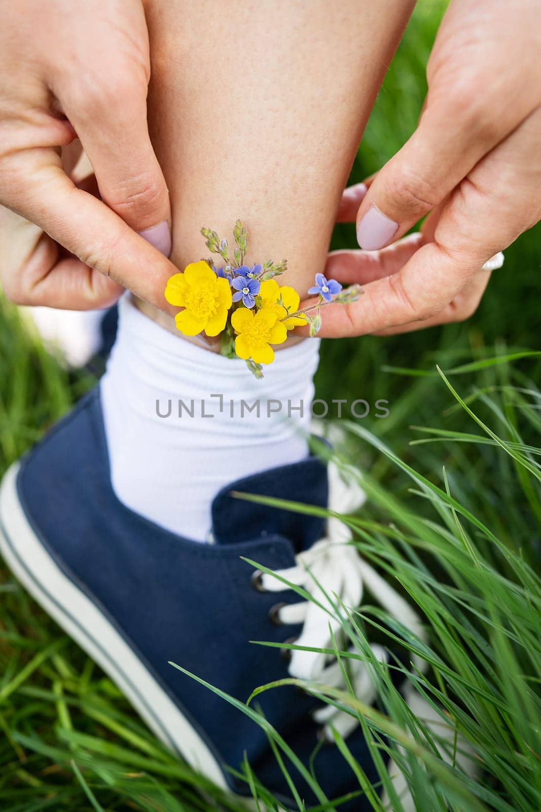 Beautiful casual shoes with delicate bright colors in socks. Fashionable stylish sports casual shoes. Flowers in blue sneakers, a classic. Close-up