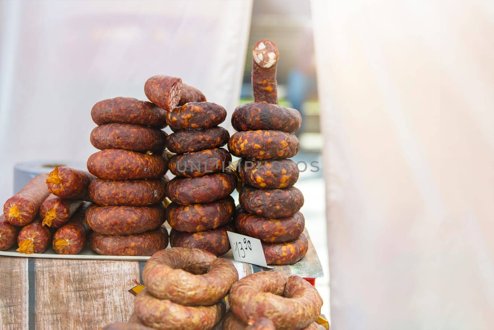 Fresh pork sausage rings lie on the counter of the meat market. Smoked meat products handmade. Buying food from meat. by SERSOL