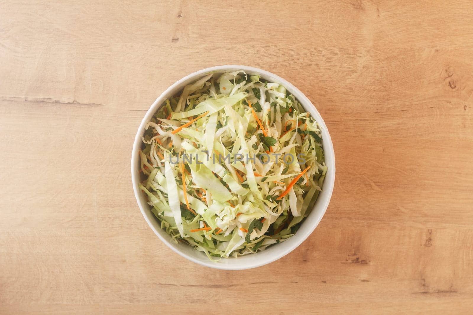 healthy vegan bowl of vegetable salad for lunch. Cabbage, carrots, parsley. View from above