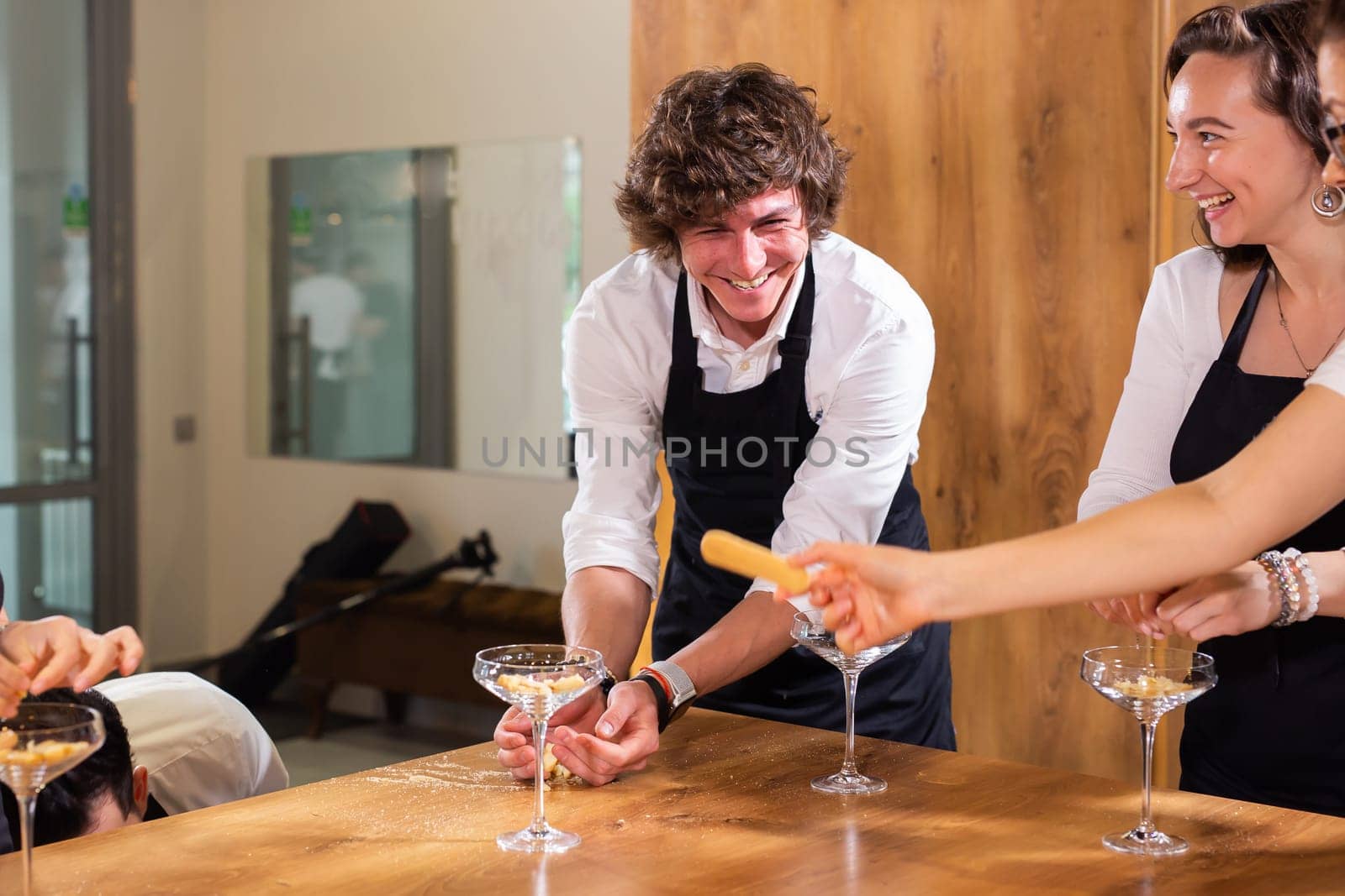 Happy chef and his colleague standing at kitchen and looking at camera - food and restaurant