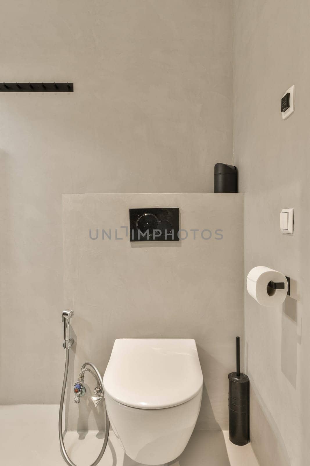 a bathroom with a toilet and shower head mounted on the wall next to it is an image of a man's face