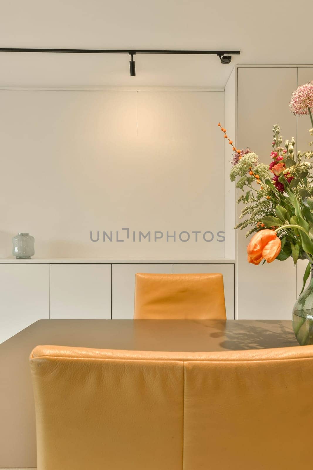 a dining room table with a vase of flowers by casamedia