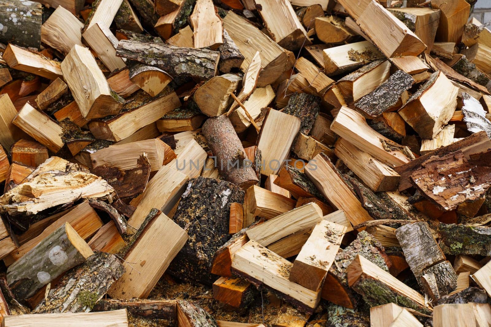 Dry chopped firewood in a pile. Abstraction and background.