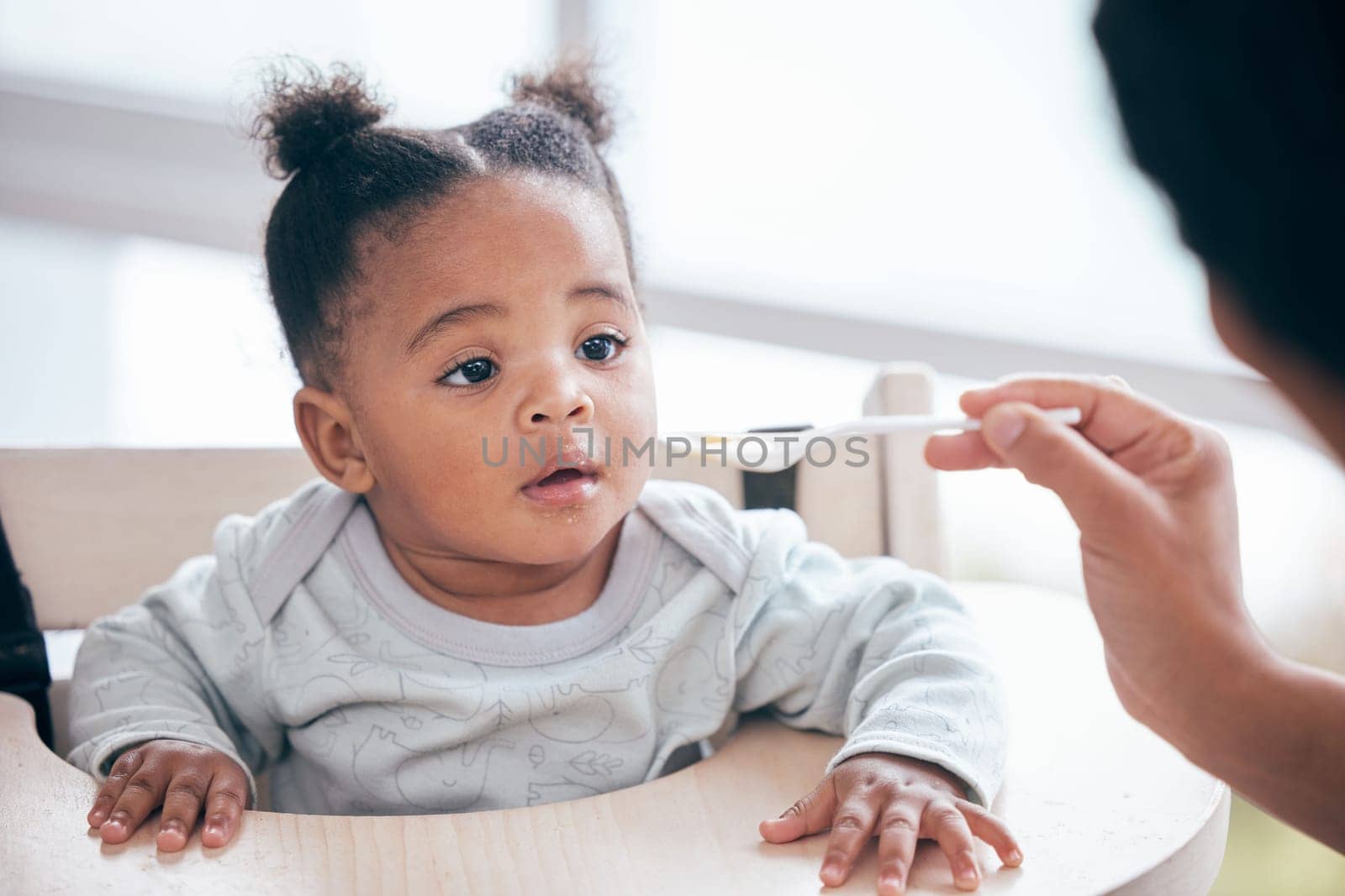 Food, breakfast and parent feeding a baby in the morning while eating porridge with a mother. Hungry, feed and African child ready to eat a meal, lunch or dinner with a mom in a family home by YuriArcurs