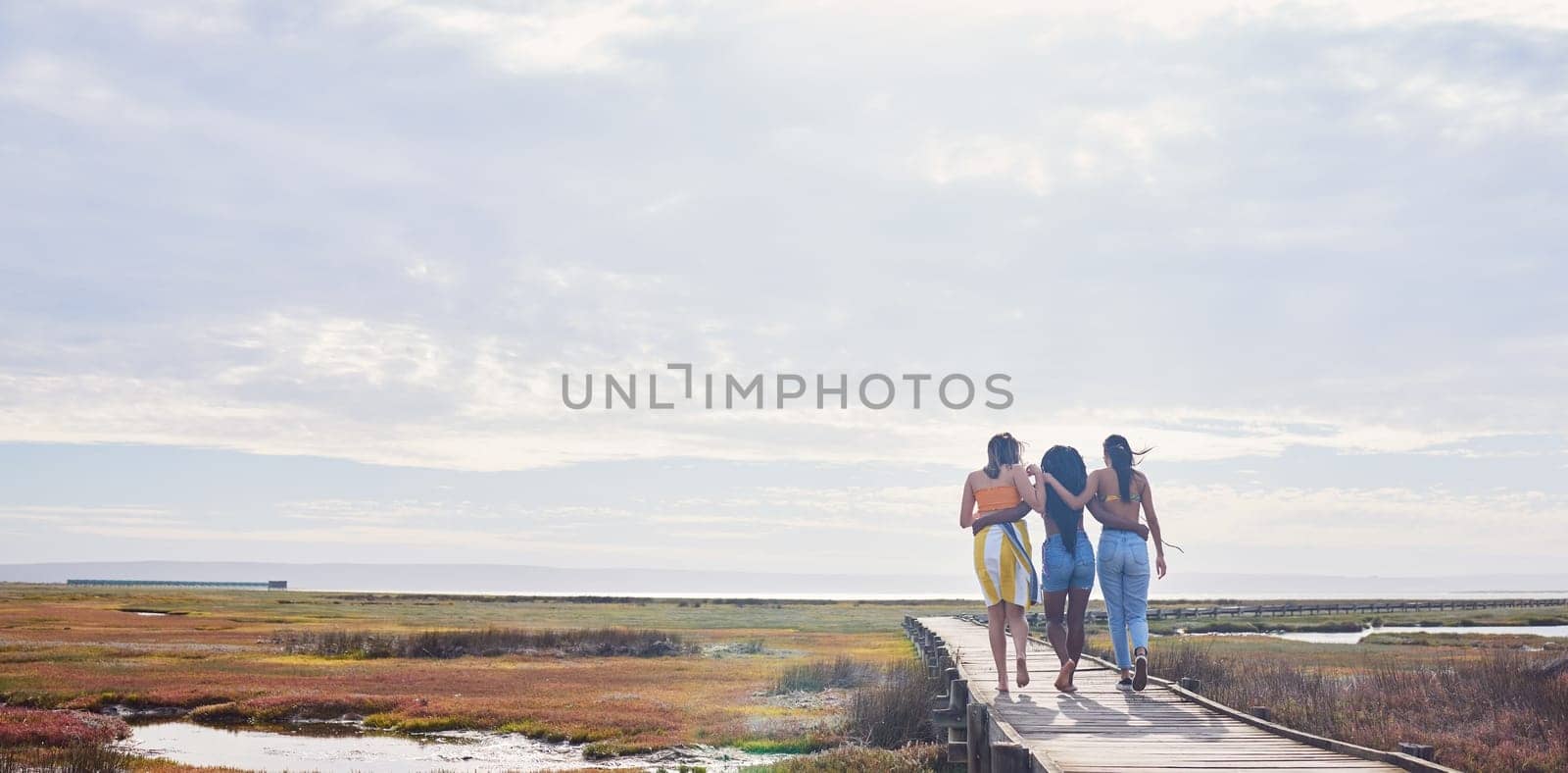 Relax, happy and boardwalk with friends at beach for travel vacation, support or summer break with sky mockup. Diversity, holiday and nature with women walking together for bonding, hug or peace.