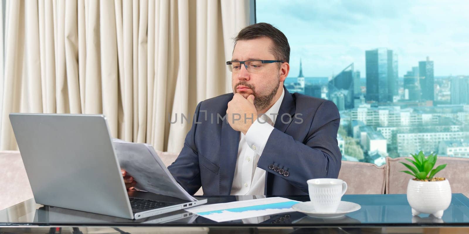Happy businessman working on laptop in home office. financial investor working in the office. Accountant working on consolidated financial report of corporate operations.