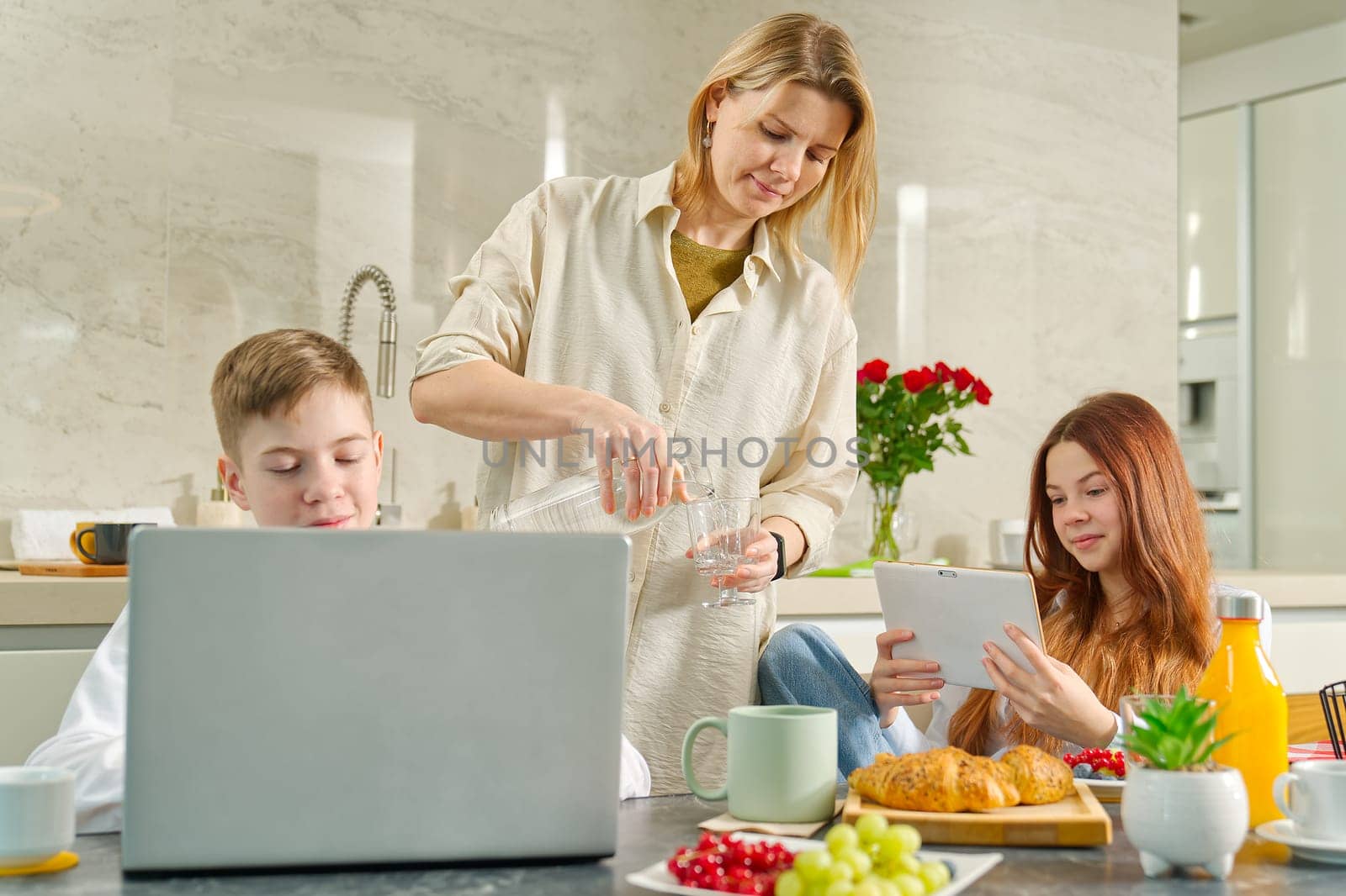 Young family with kids have fun at breakfast time. Happy family eating healthy breakfast together. by PhotoTime