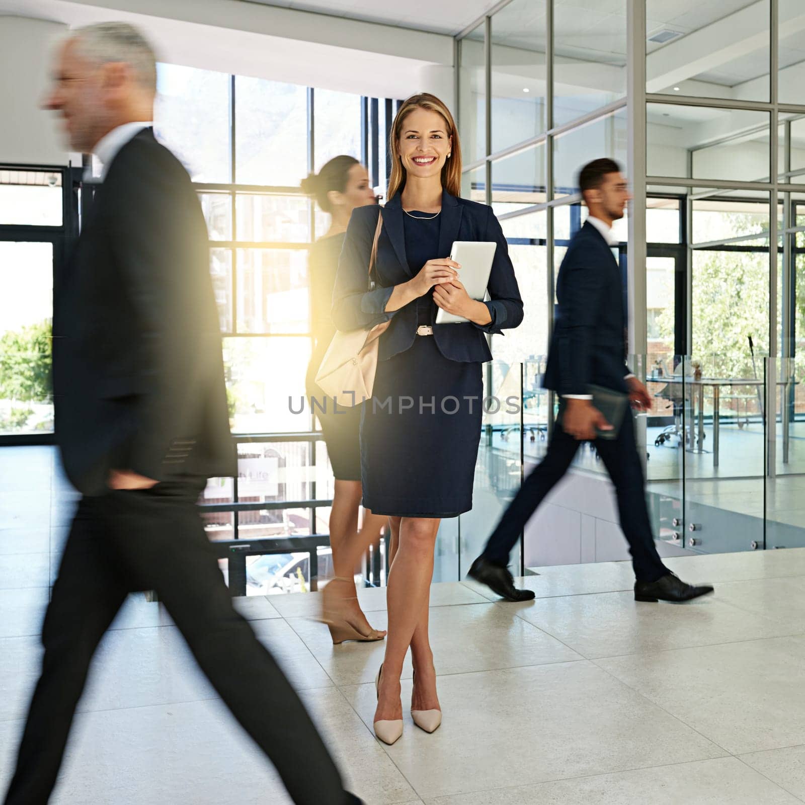 I love the busy office vibe. Portrait of a young businesswoman standing in a busy office. by YuriArcurs