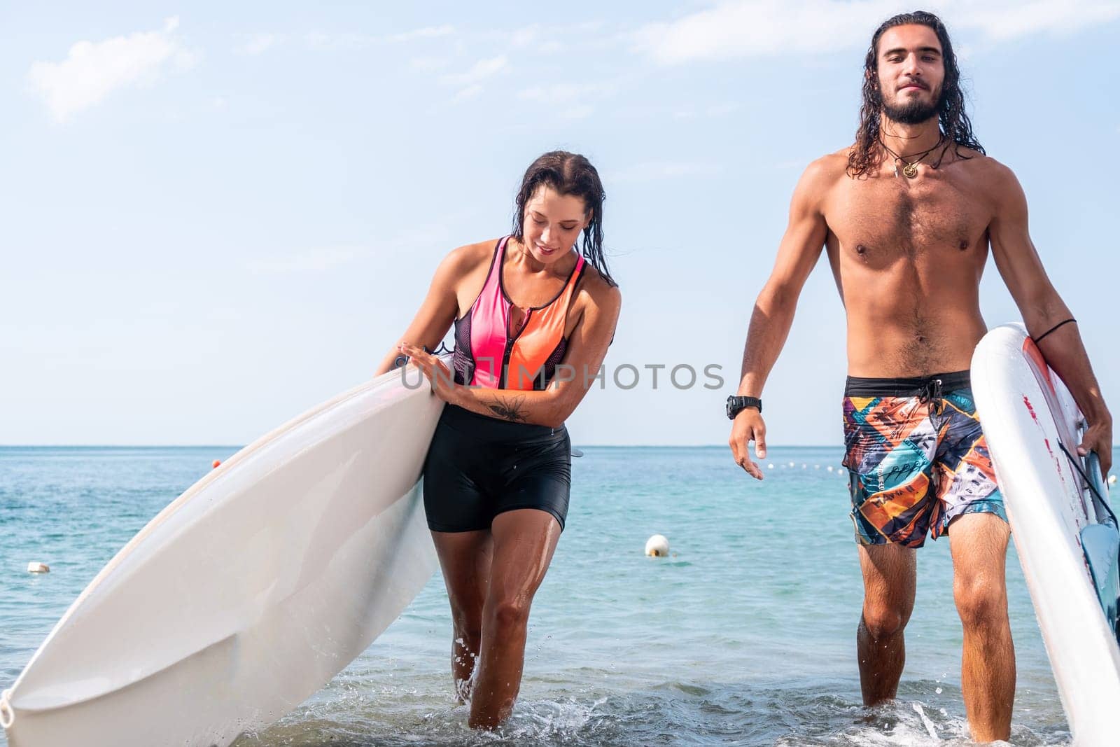 Woman man sea sup. Close up portrait of beautiful young caucasian woman with black hair and freckles looking at camera and smiling. Cute woman portrait in a pink bikini posing on sup board in the sea by panophotograph