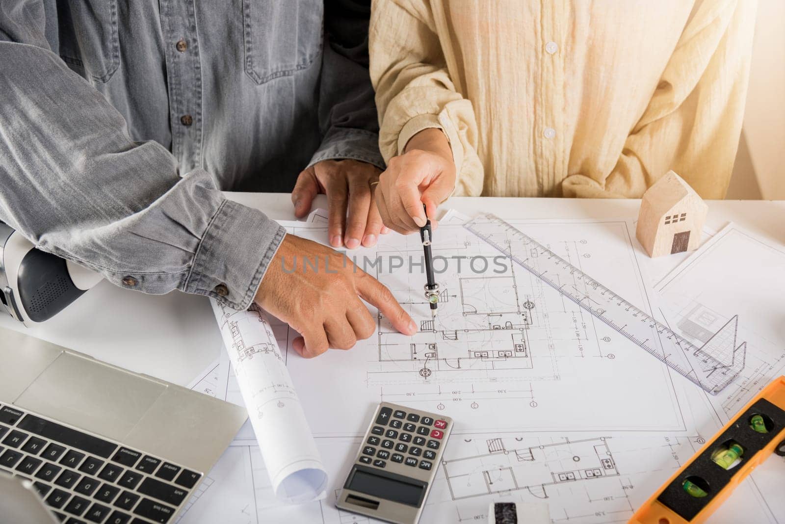 Two engineers pointing at drawings project, Architect team meeting consult and work for architectural construction project working with partner and engineering after editing on blueprint paper plans
