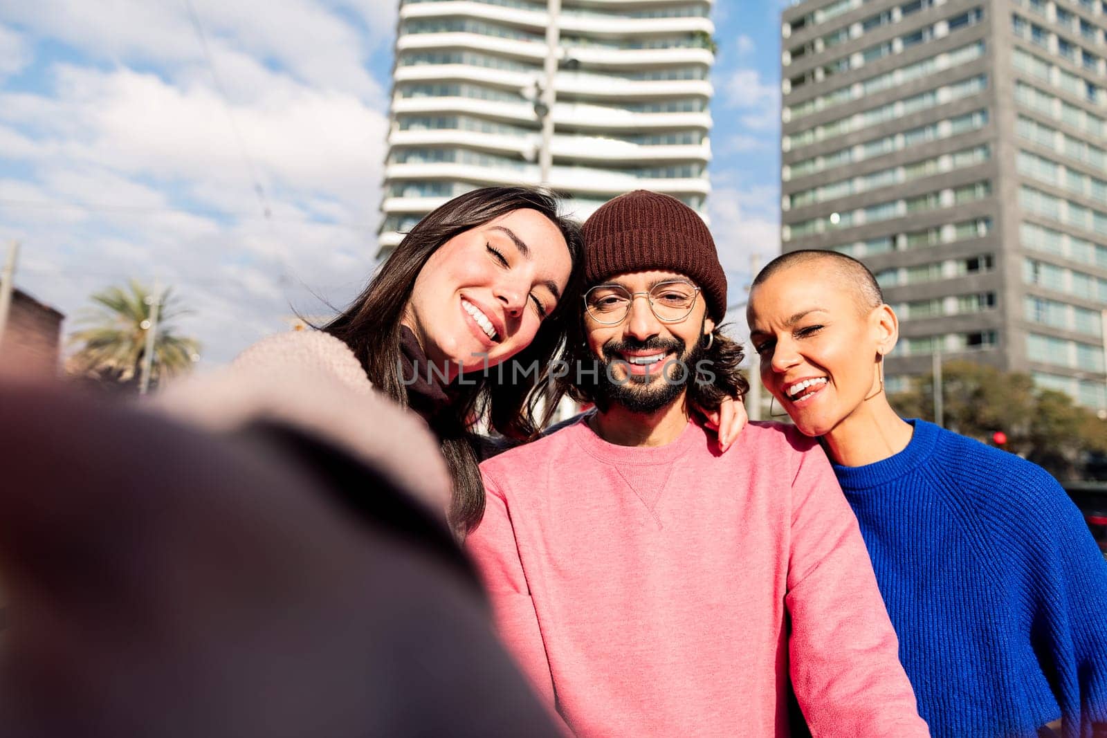 selfie photo of three happy friends smiling in the city, concept of friendship and urban lifestyle