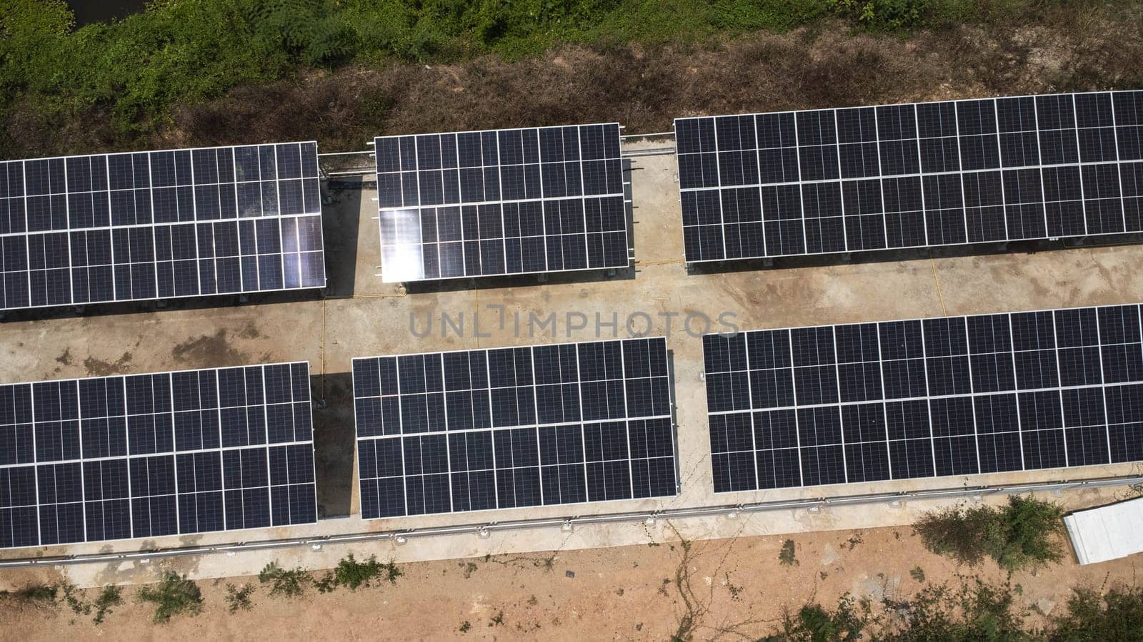 Top view on photovoltaic solar power panels. Drone aerial view of solar panels with water pumps, agricultural equipment for irrigation near rivers from clean energy or solar energy. Alternative electricity source. by TEERASAK