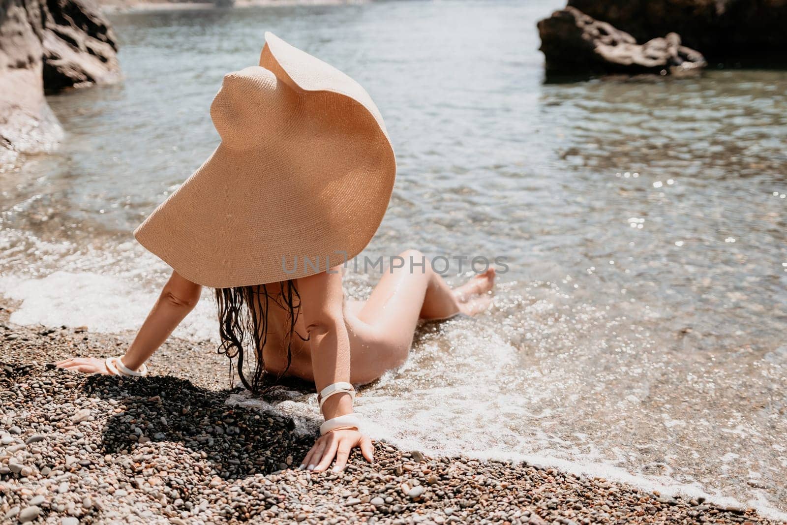 Woman travel sea. Happy tourist in hat enjoy taking picture outdoors for memories. Woman traveler posing on the beach at sea surrounded by volcanic mountains, sharing travel adventure journey by panophotograph