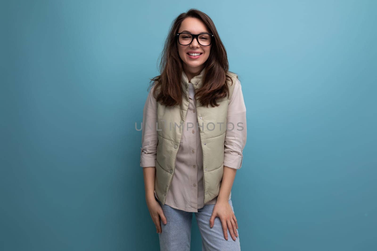 portrait of a well-groomed young brunette woman correcting her eyesight using glasses on a studio background with copy space.