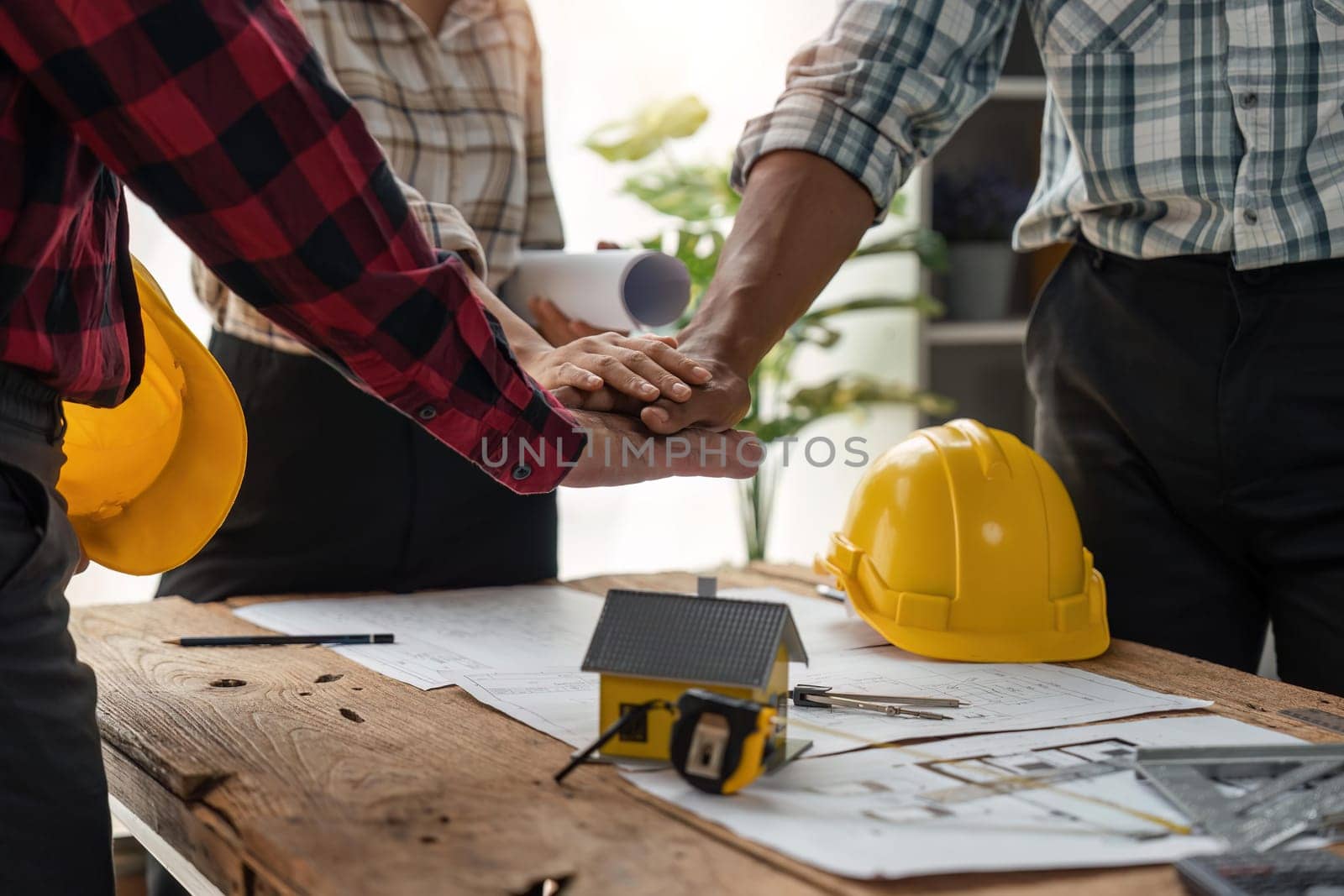 construction team handshake greeting start new project contract plan in office center at construction site partner and contractor yellow hard hat on table and house design print design by nateemee