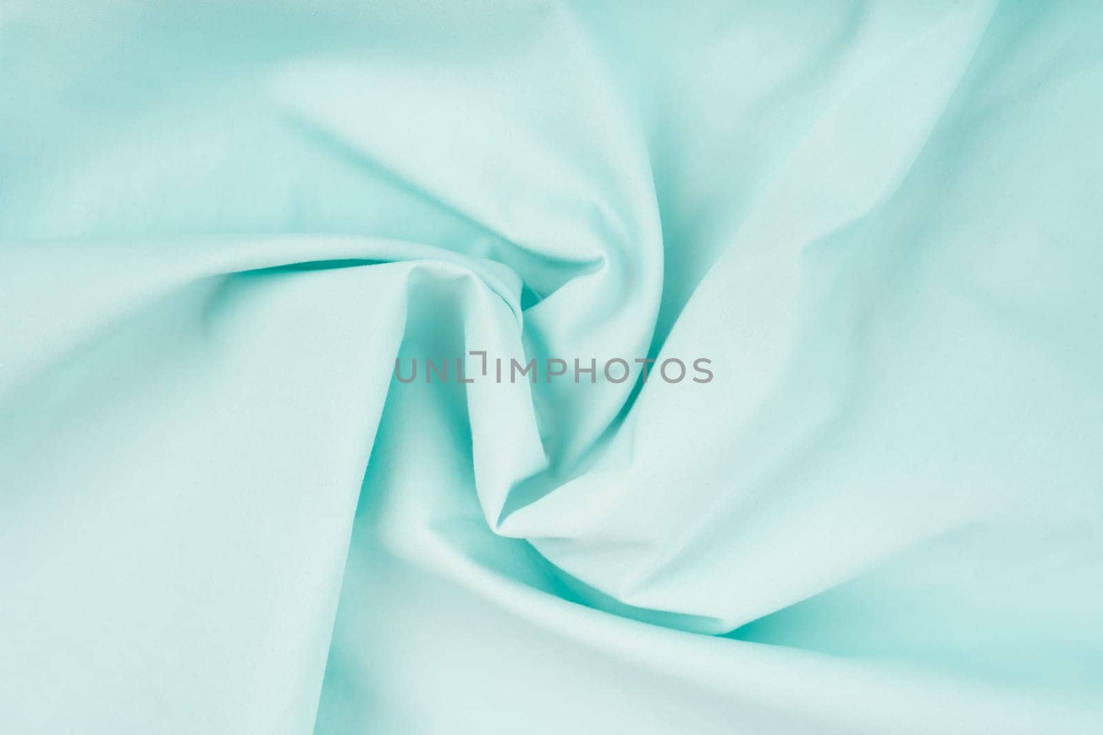 Delicate background of light blue soft plush fleece with embossed folds and waves. A modern backdrop for decorating and designing textiles.