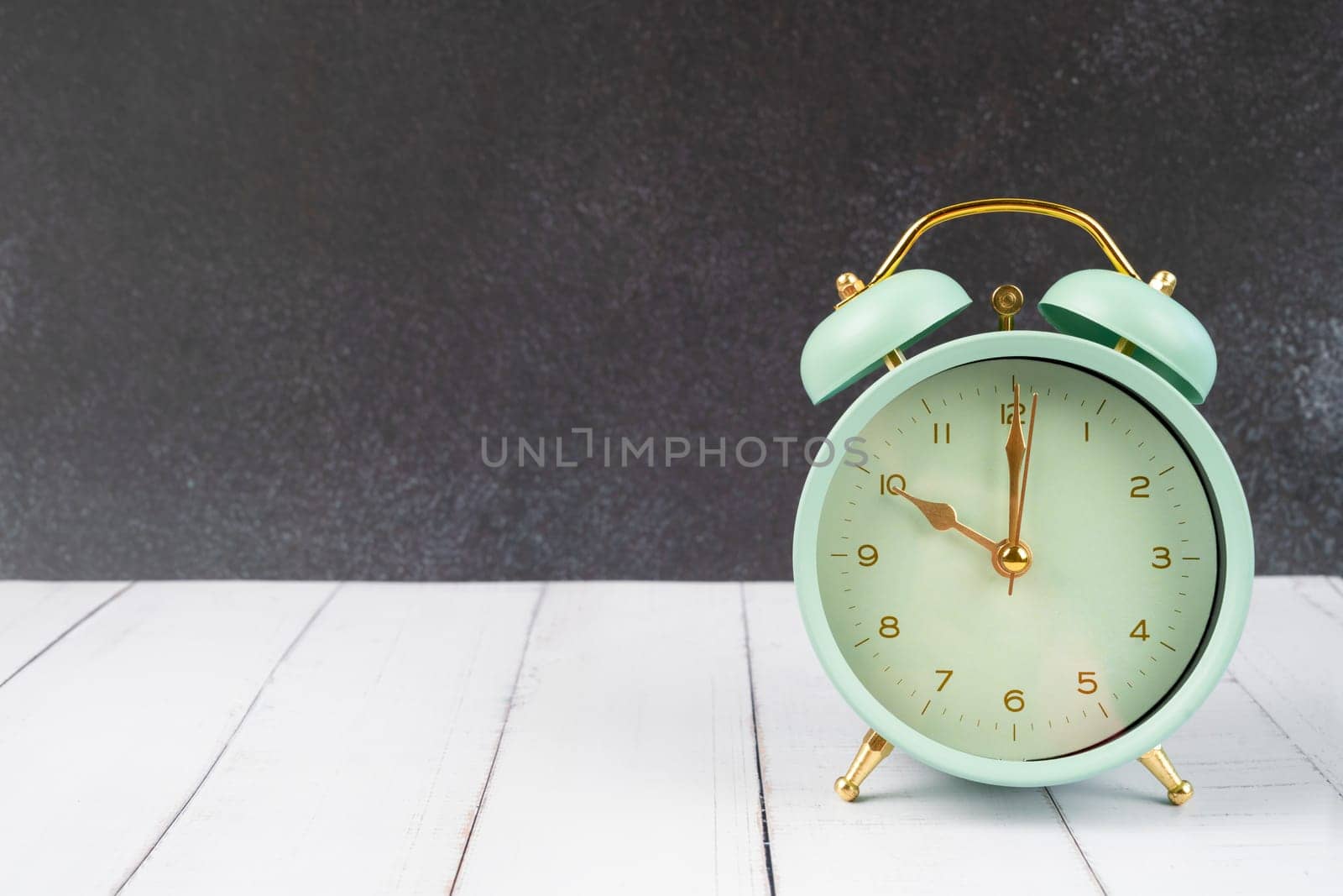 vintage retro alarm clock ten time o'clock on table wood with dark background.