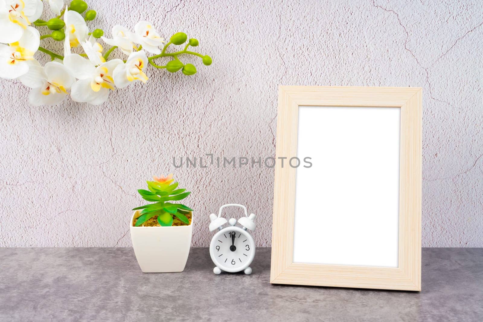 Blank picture frame and alarm clock on black floor with copy space and clipping path for the inside.