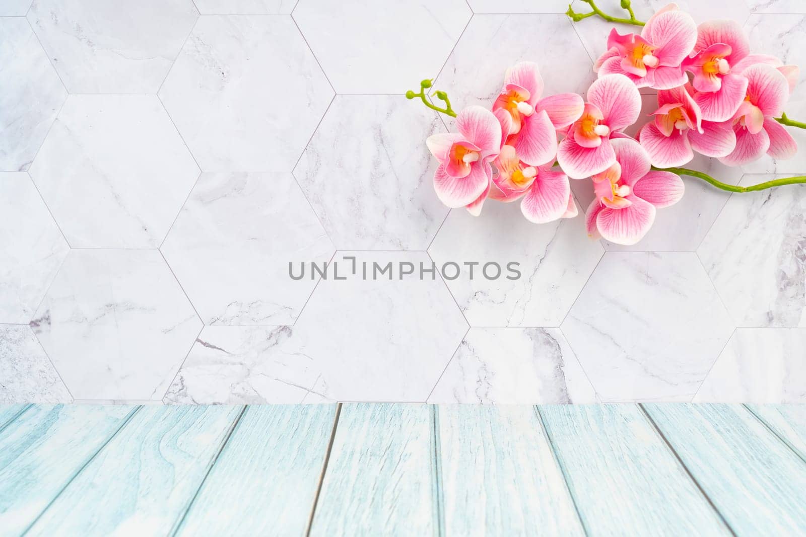 Wooden floor and marble wall with pink color orchid decorate, empty room for background.