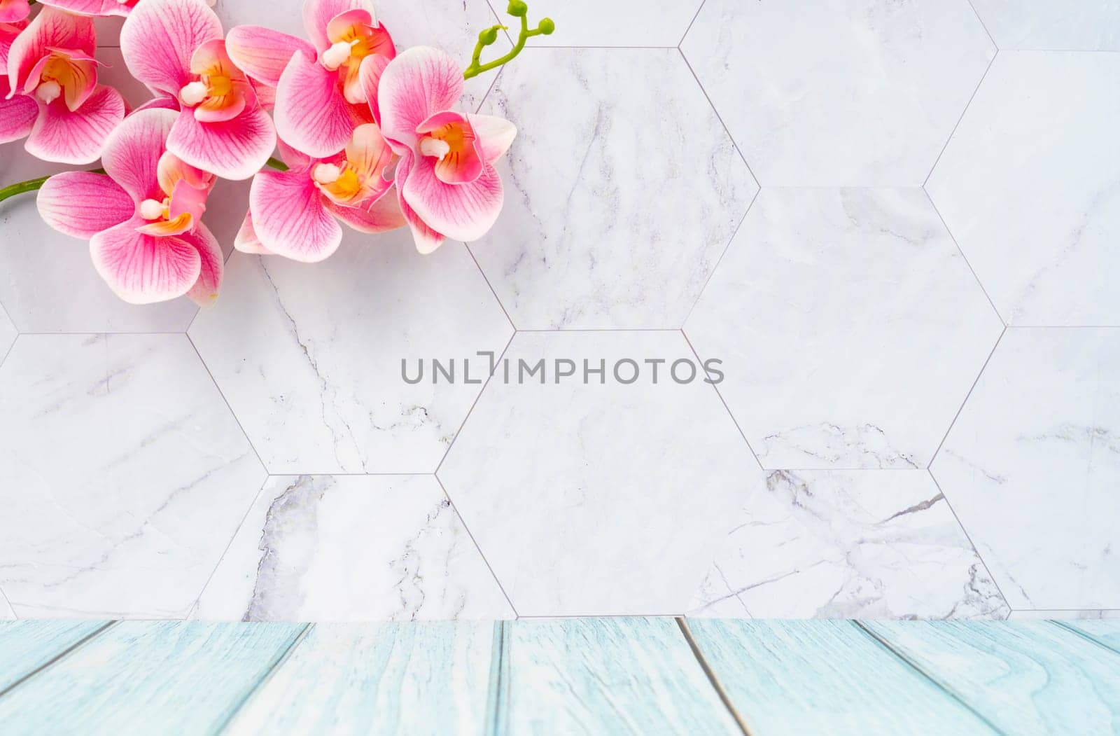 Wooden floor and marble wall with pink color orchid decorate, empty room for background.