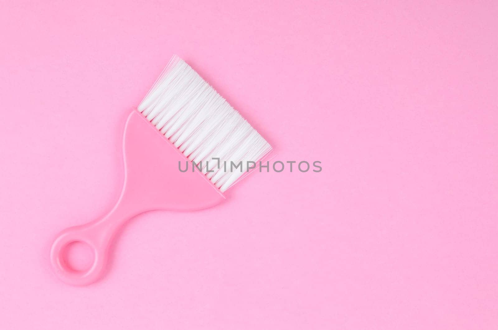 The Pink cleaning brush on pink background. by Gamjai