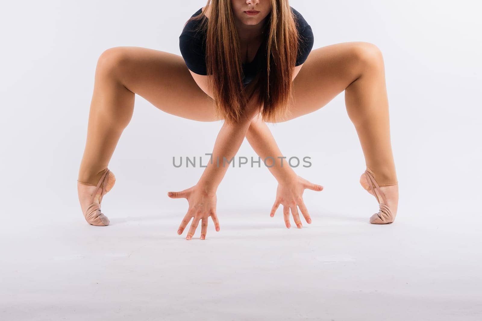 Flexible girl, rhythmic gymnastics artist jumping on white dark background. Grace in motion, action. by Zelenin