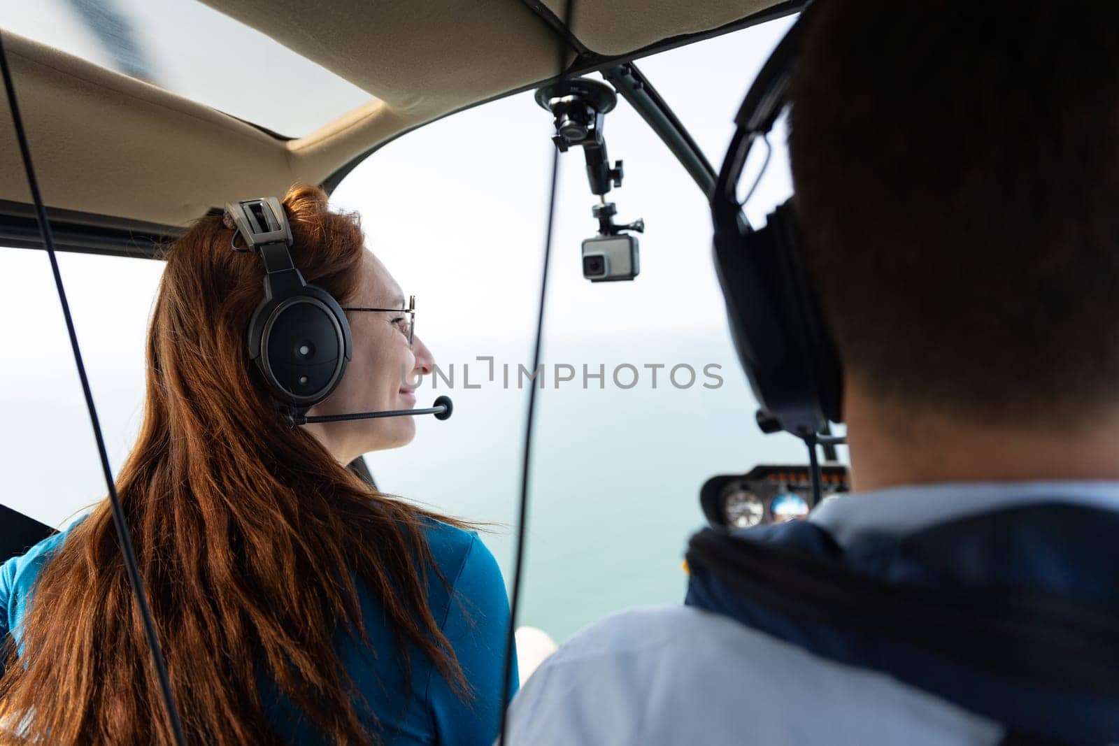 Smiling woman sitting in passenger seat in helicopter. Mid shot