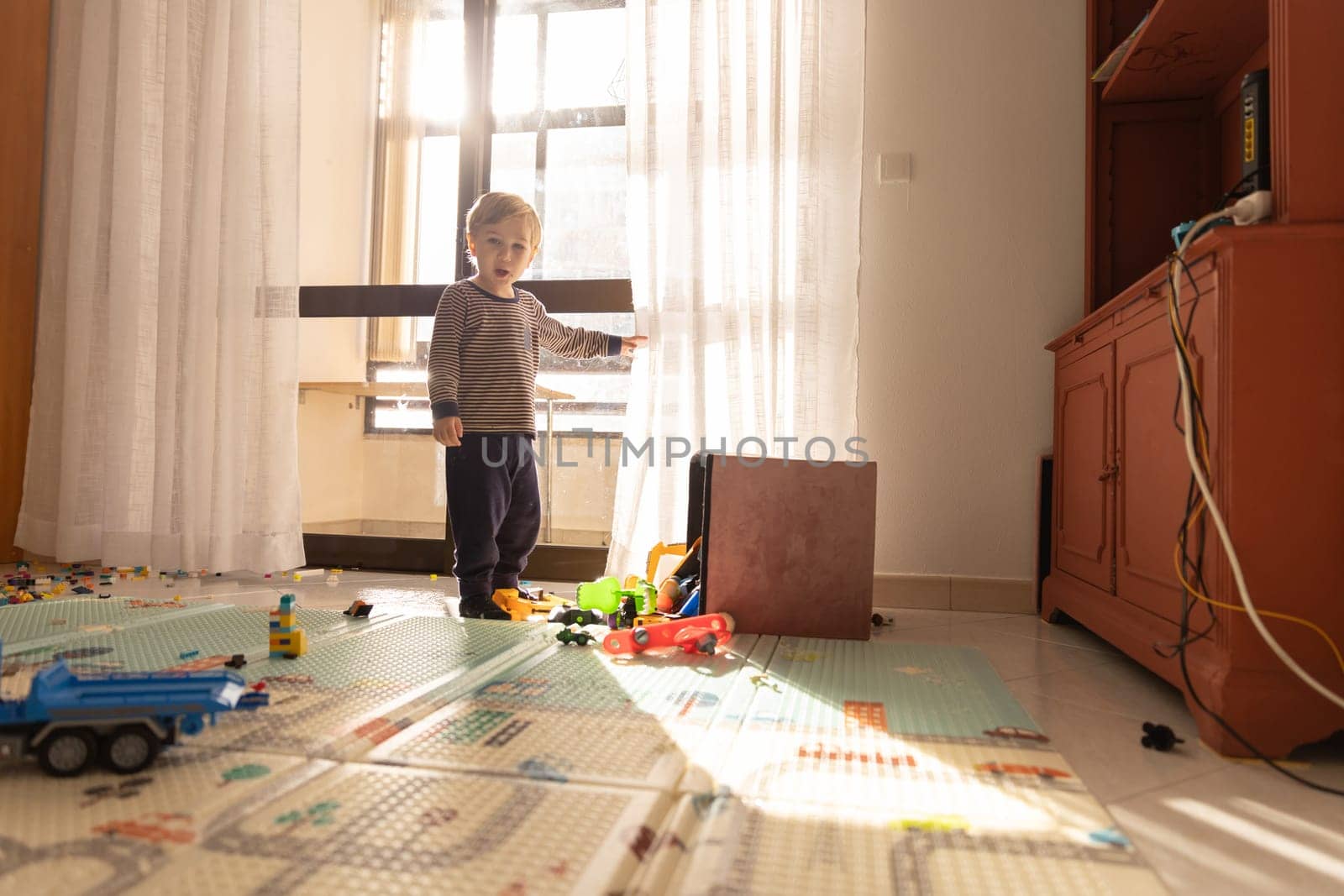 Cute blonde baby boy in the play room. Mid shot