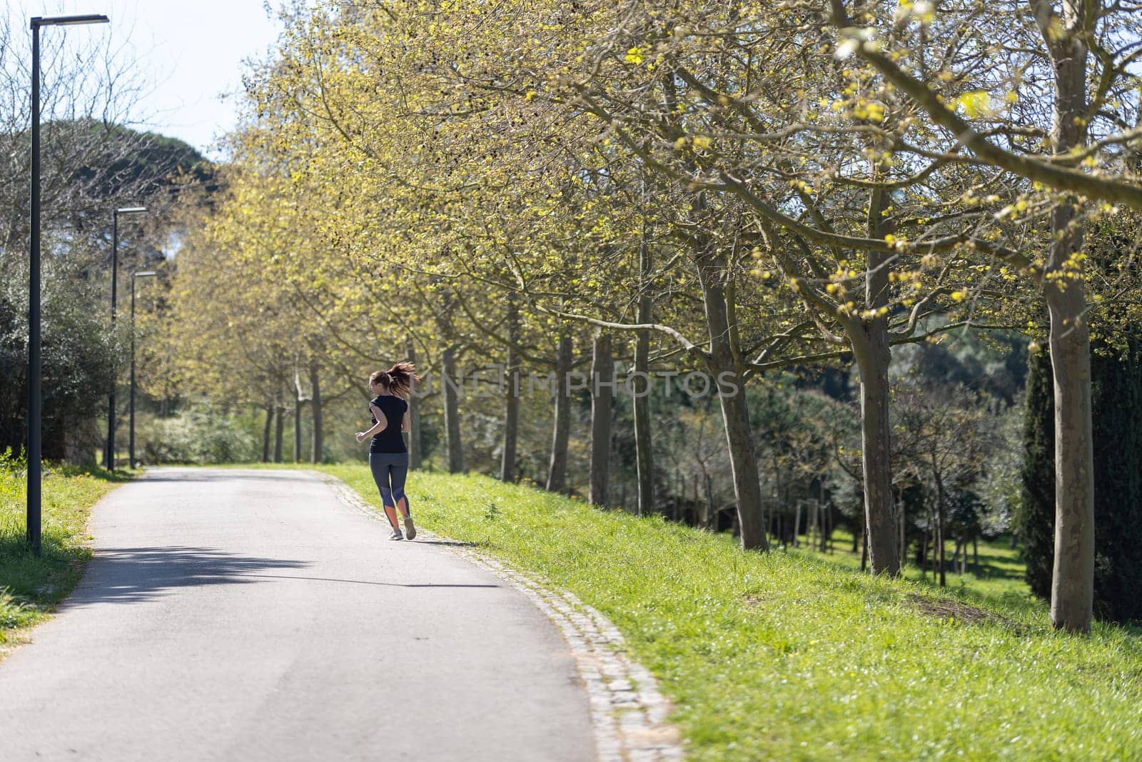 Adult fitness woman jogging on nature. Mid shot