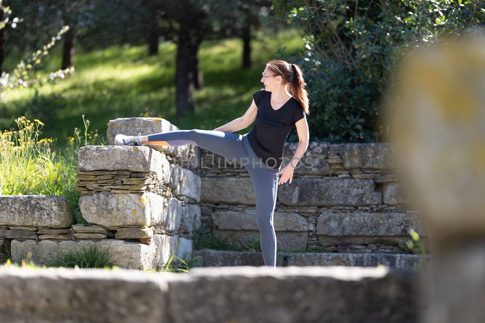 Fitness concept - adult woman does stretching. Mid shot