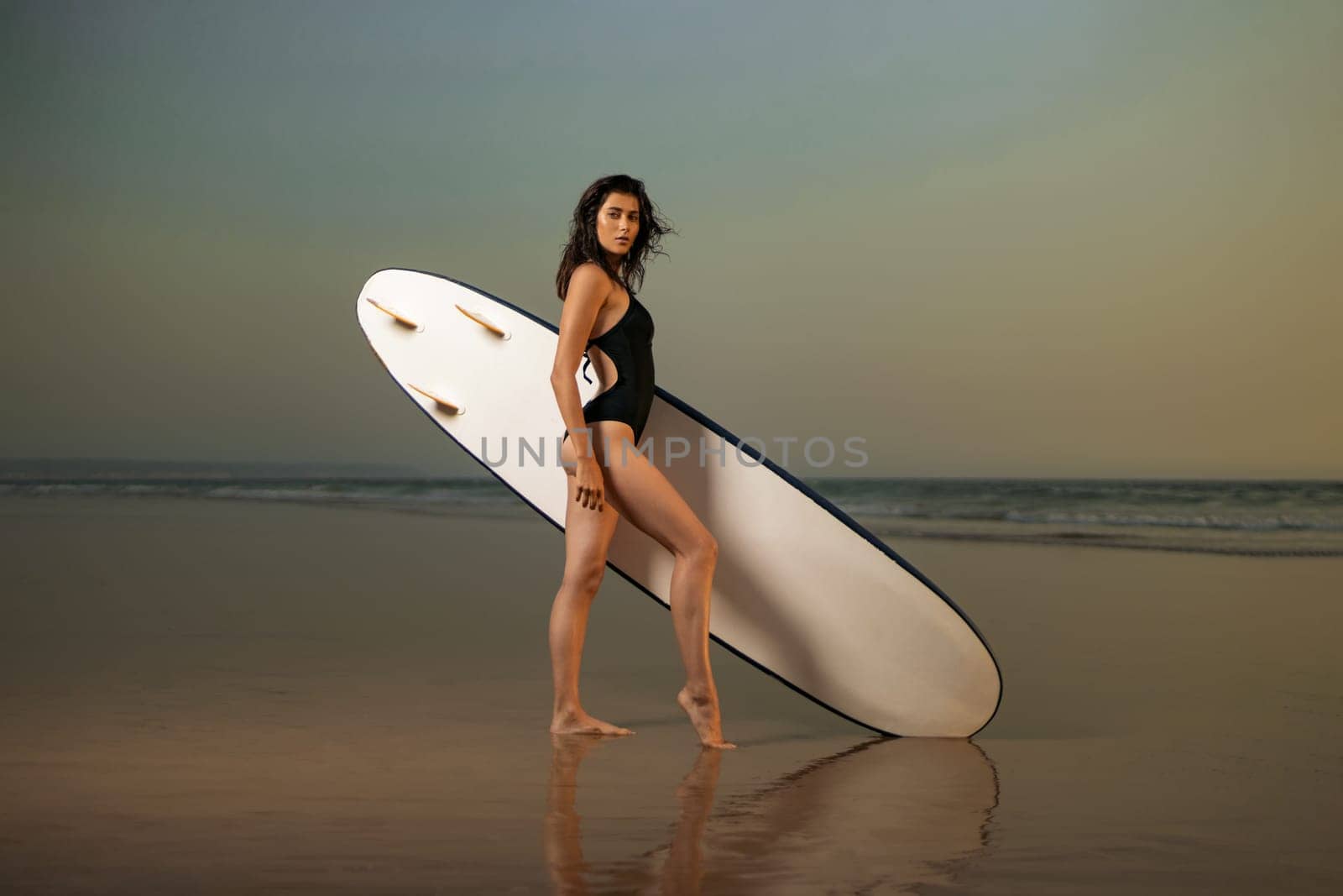 Download high resolution photo of a surfer girl. Advertisement for surfing in Nazare, Portugal