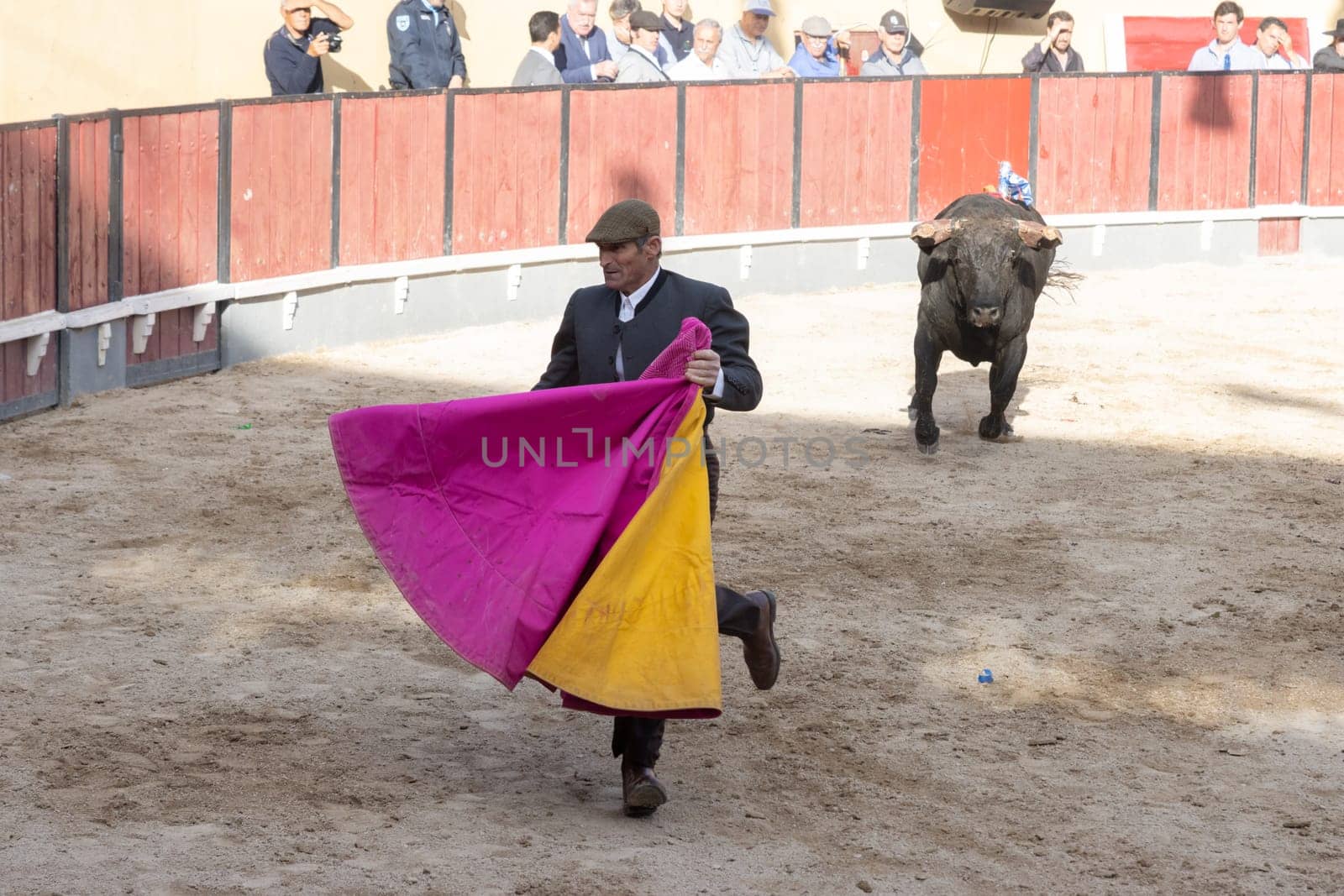 March 26, 2023 Lisbon, Portugal: Tourada - bullfighter run away from the bull holding a bright rag. Mid shot