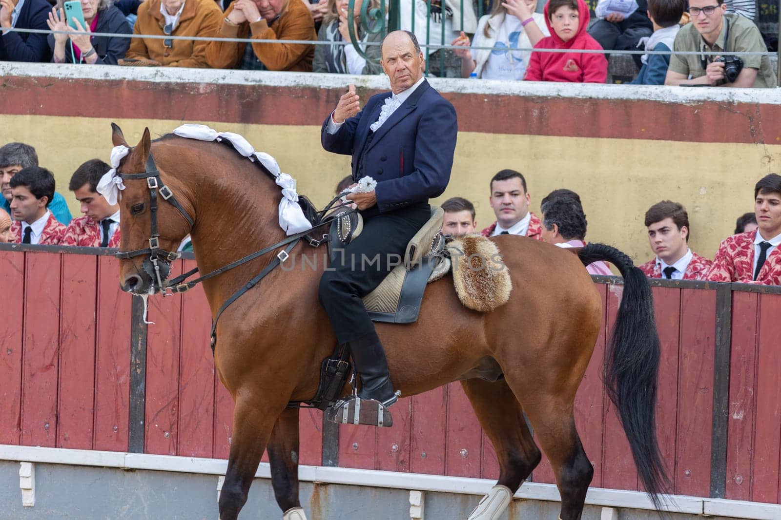 March 26, 2023 Lisbon, Portugal: Tourada - man in suit cavaleiro on a horseback on arena of amphitheater. Mid shot