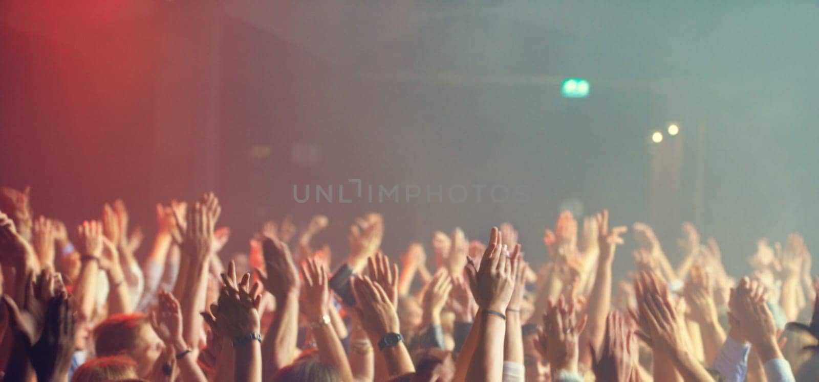 A crowd of people celebrating and partying with their hands in the air to an awesome band. This concert was created for the sole purpose of this photo shoot, featuring 300 models and 3 live bands. All people in this shoot are model released