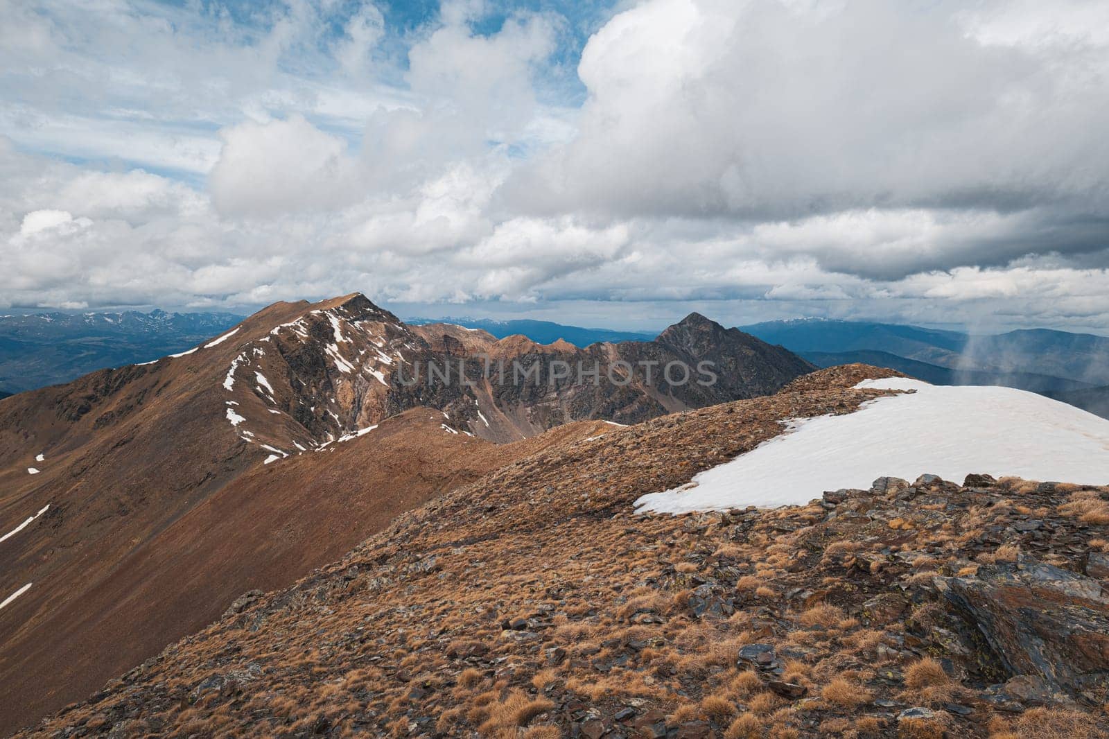 Panoramic unique view of the steep snowy slopes on a cloudy day in the Pyrenees mountains on the sky. The concept of Spanish-French national parks. Copyspace.