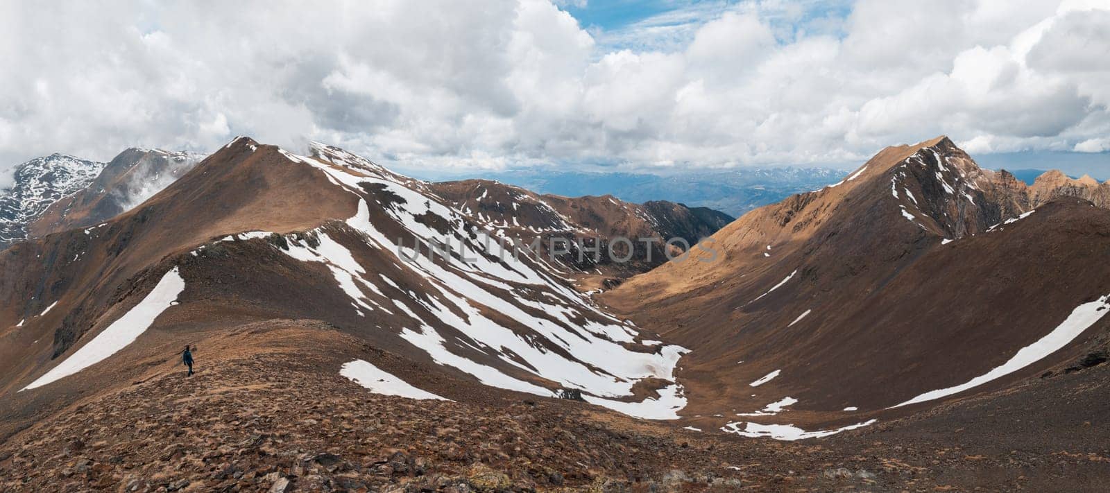 Panoramic beautiful view of the steep snowy slopes on an autumn day in the Pyrenees mountains on a cloudy sky. The concept of Spanish national mountain parks. Copyspace.