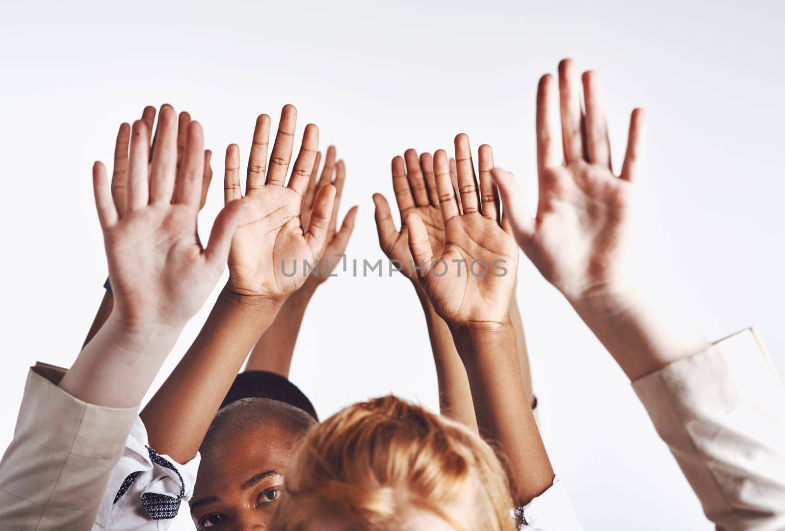 Be ready to grab opportunity with both hands. Shot of a group of hands reaching up against a white background. by YuriArcurs