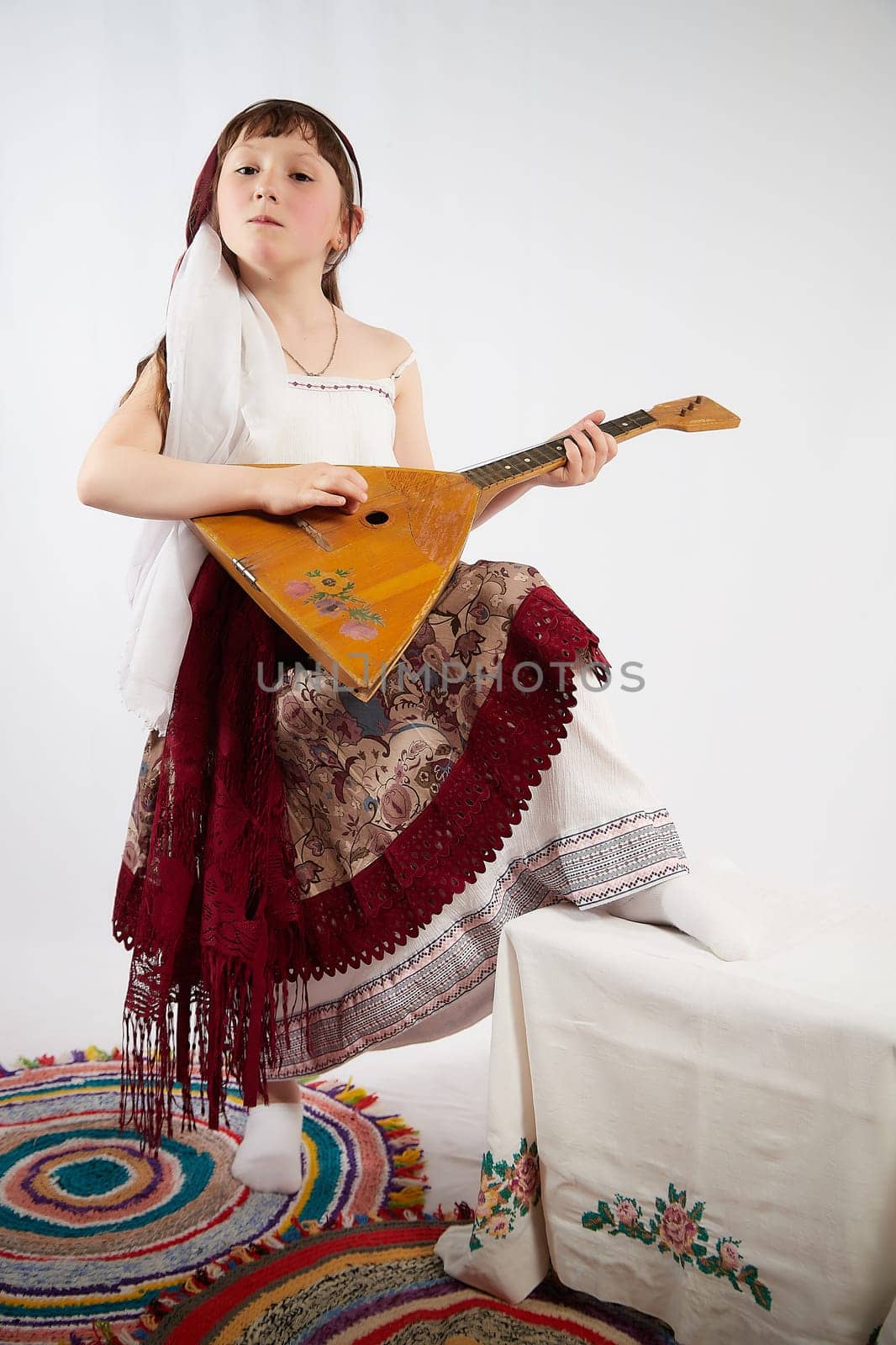 Portrait of Little girl in a stylized Tatar national costume on a white background in the studio. Photo shoot of funny young teenager who is not a professional model