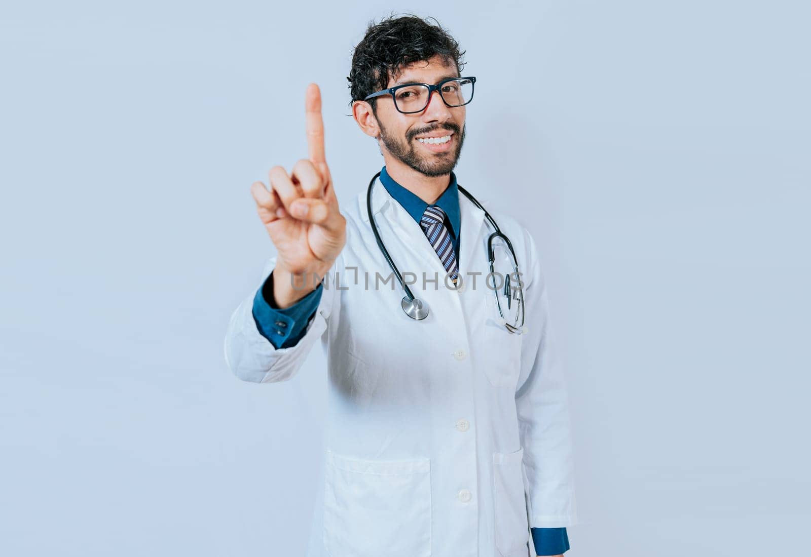 Doctor counting number ONE isolated. Handsome doctor counting number 1 on isolated background. Young doctor raising index finger isolated