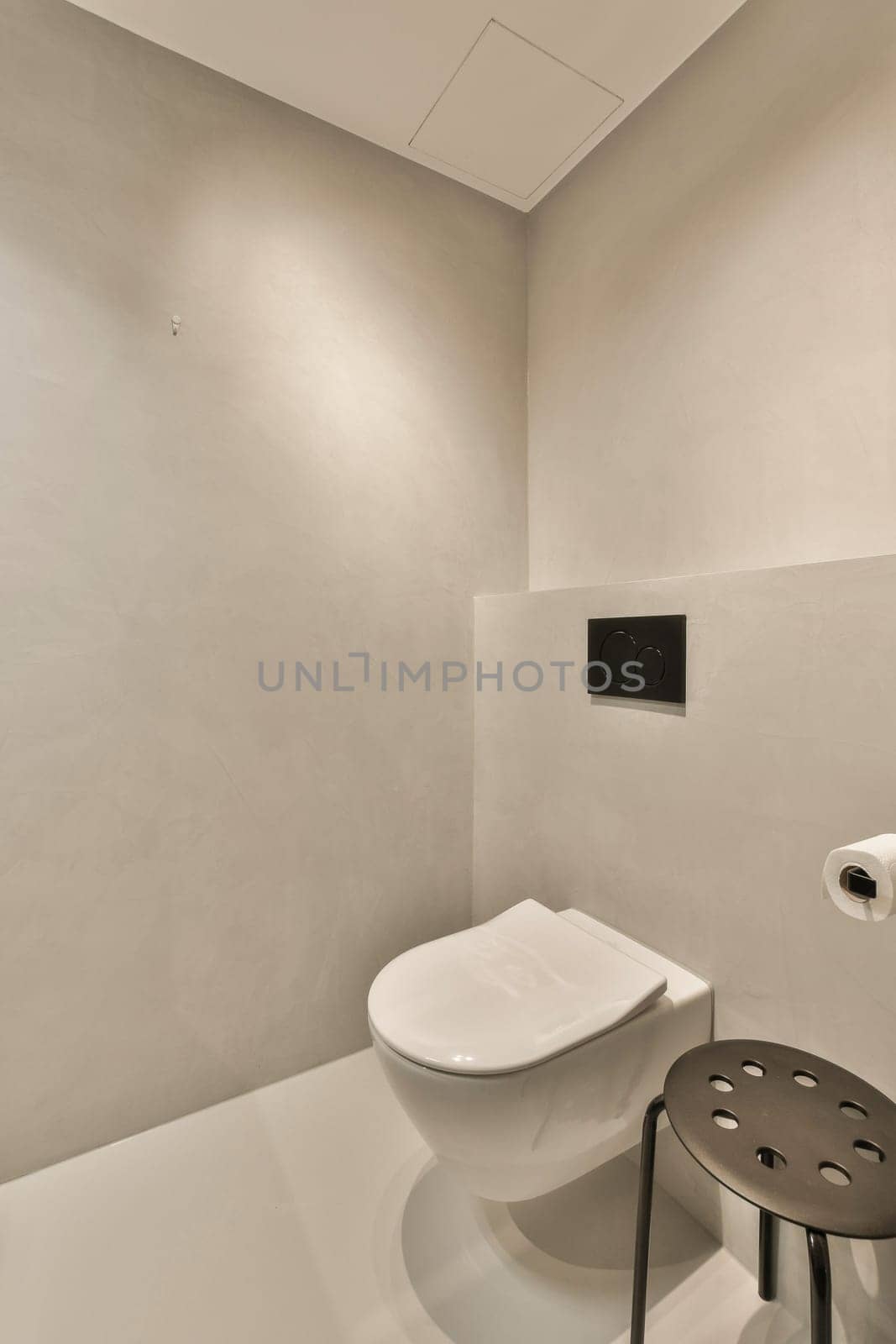 a small bathroom with a toilet and a stool by casamedia