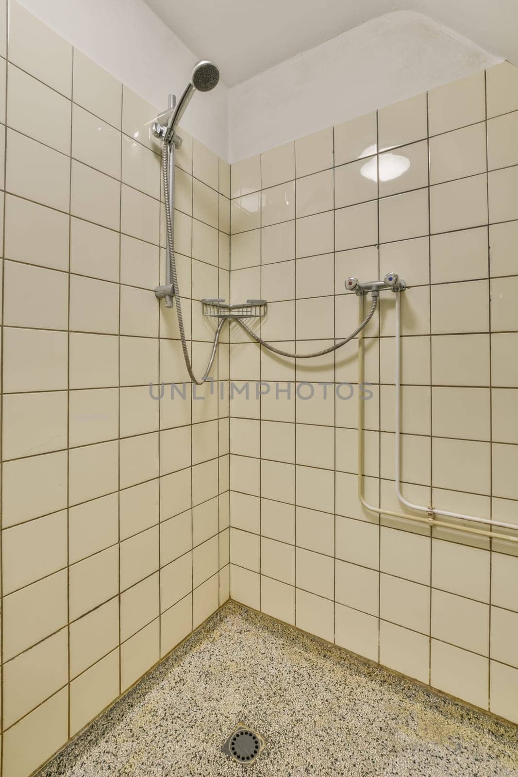a white tiled shower stall in a bathroom with by casamedia