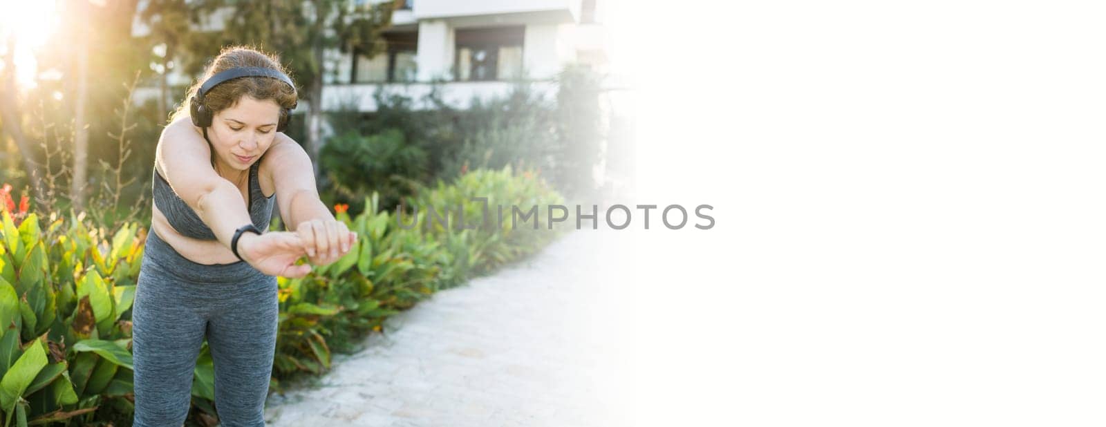 Young pretty smiling plus size woman in sporty top and leggings doing sport in summer outdoor