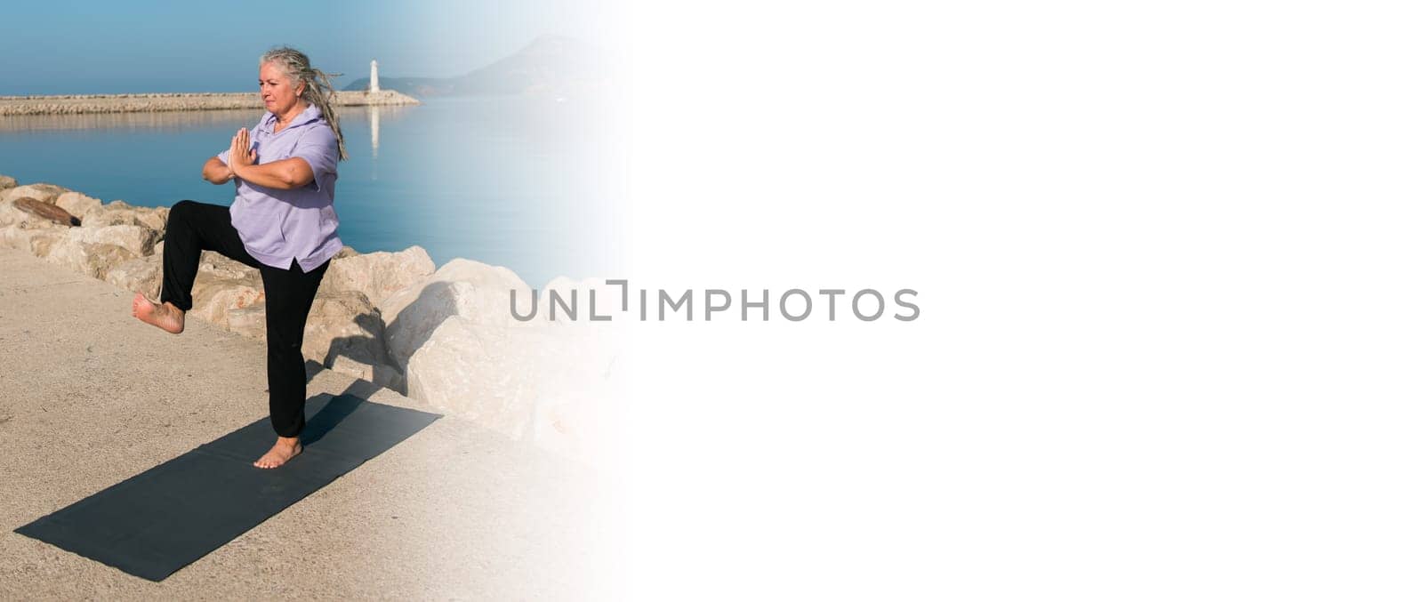 Banner mature woman with dreadlocks working out doing yoga exercises on sea beach copy space - wellness well-being and active elderly age concept by Satura86