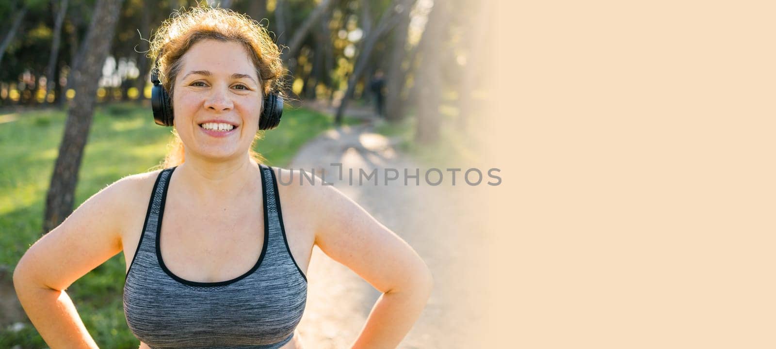 Banner Fat woman and sports. Girl doing exercise for weight loss in the fresh air and laughing in camera after training. Copy space and empty space for text or advertising by Satura86
