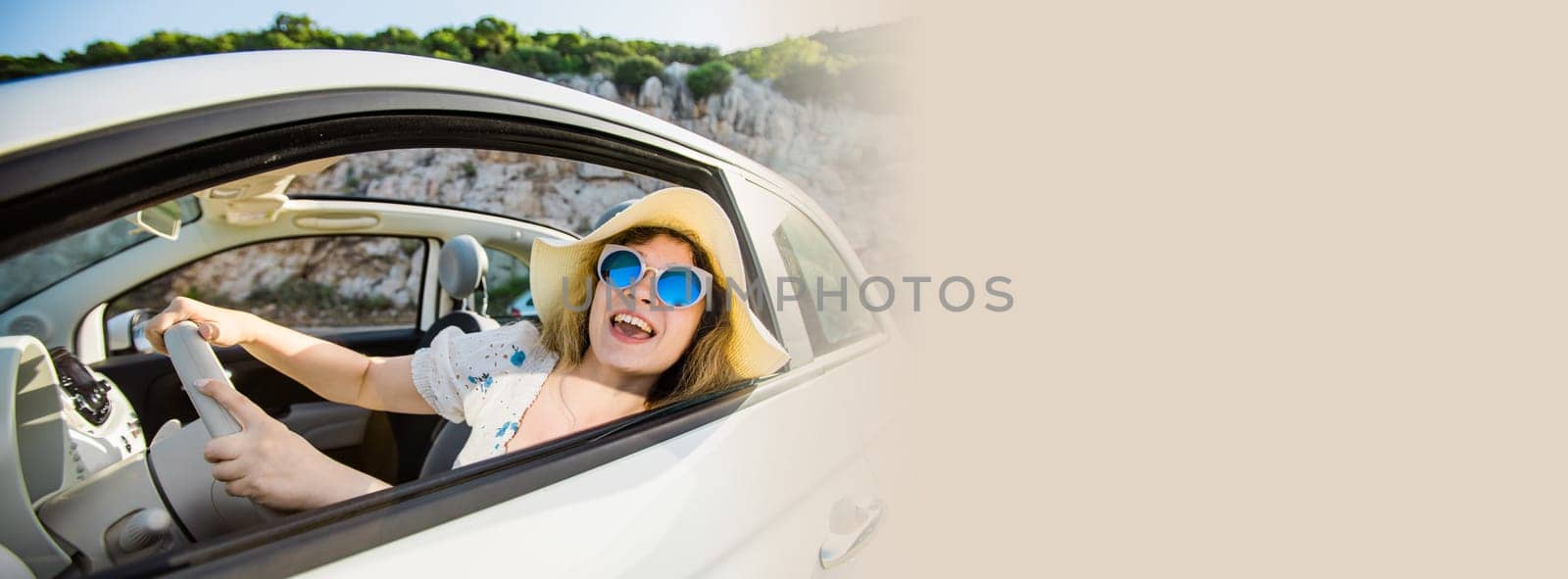 Smiling blonde caucasian woman wearing hat and sunglasses enjoying her summer road trip in cabrio . Freedom. Travel. Tourism. Vacation.