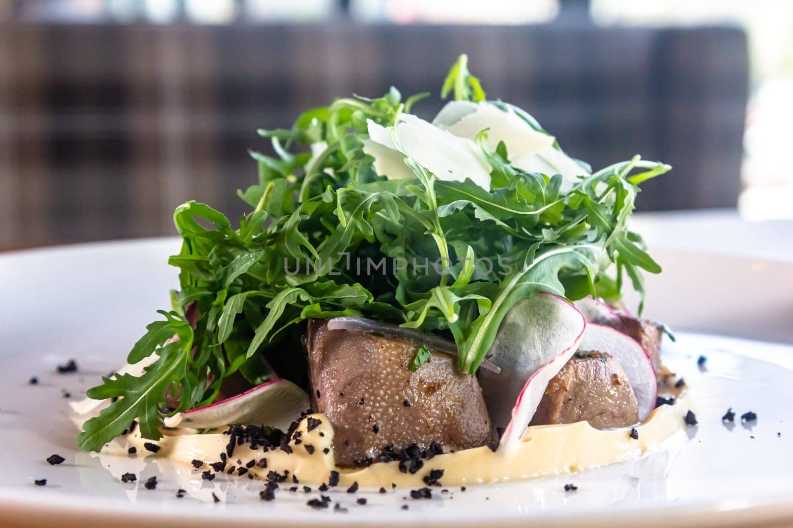Prepared beef tongue served with mixed green vegetables salad.