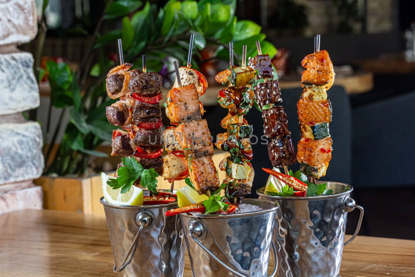 A lot of mini-kebabs of meat, fish, chicken, shrimp, vegetables on wooden skewers by Milanchikov